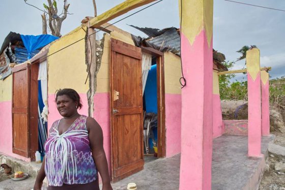 Seurette Mathieu stands in front of her house she shares with four others, which lost its roof in Hurricane Matthew. Photo by Thomas Hudson  Day 2 of 30 in our series of photos called #onehundredforhaiti #hopeandsurvival"  See them all on Facebook at http://tinyurl.com/HopeAndSurvival